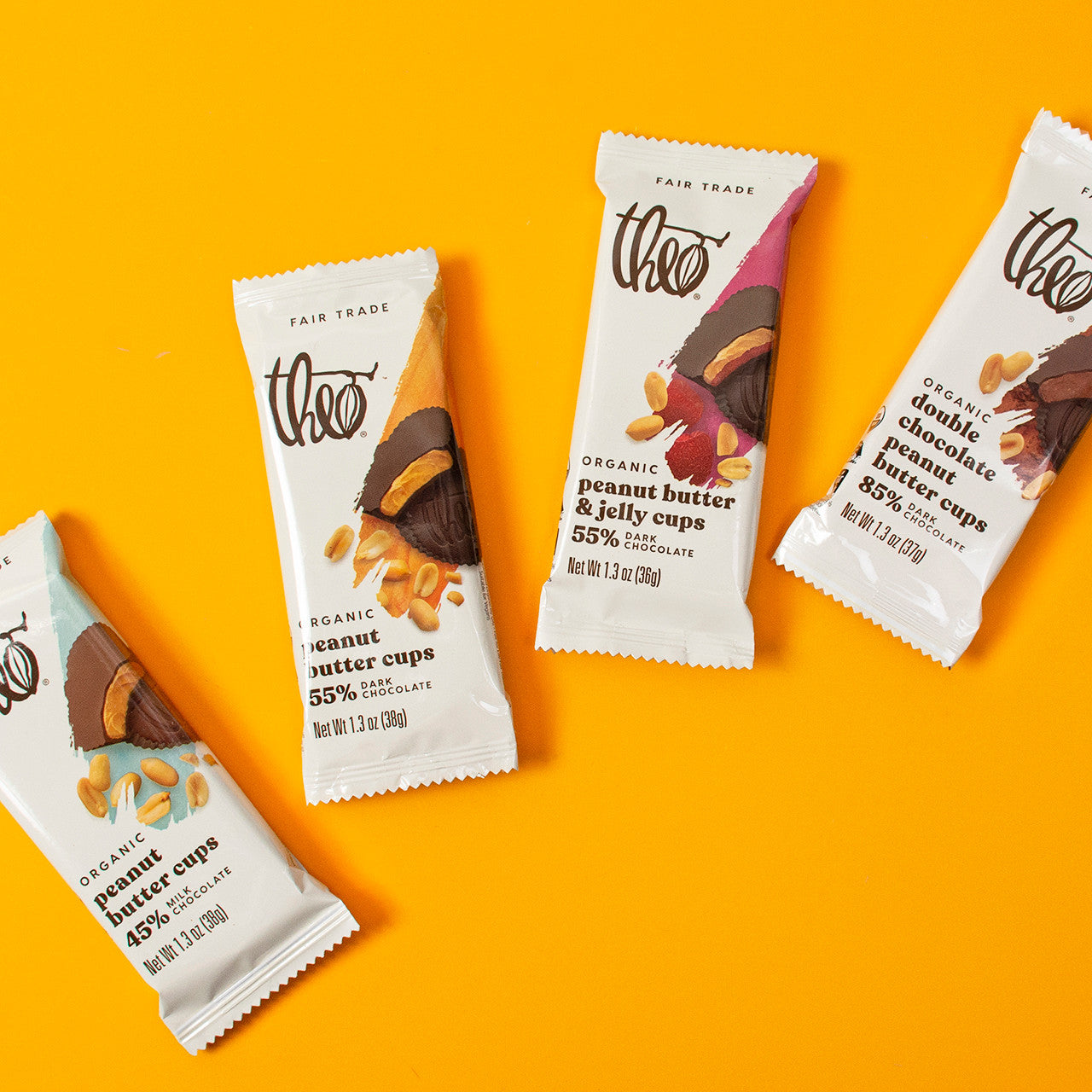 Four packages of Theo Organic Peanut Butter Cups on an orange background