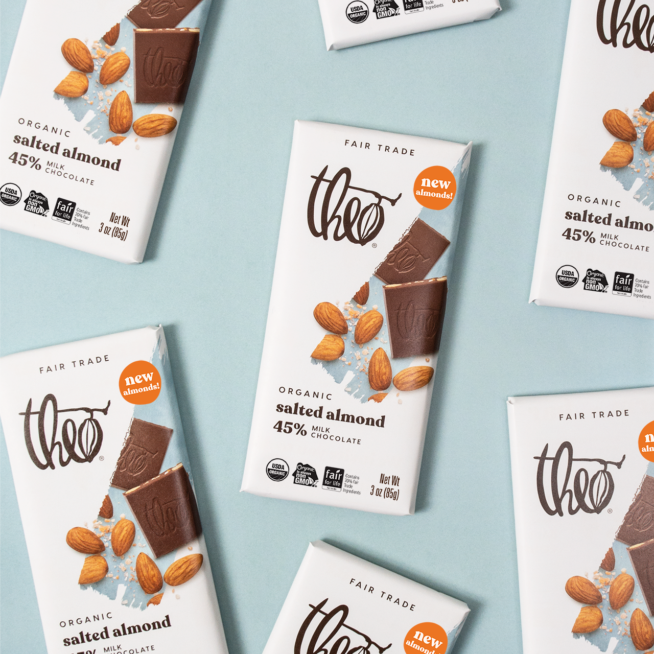 Multiple Theo Organic salted almond chocolate bars on a light blue background