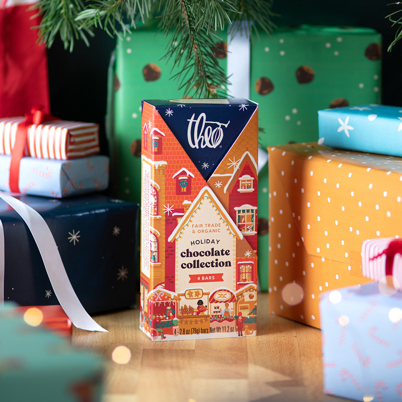 Theo holiday chocolate collection box with Christmas presents in the background