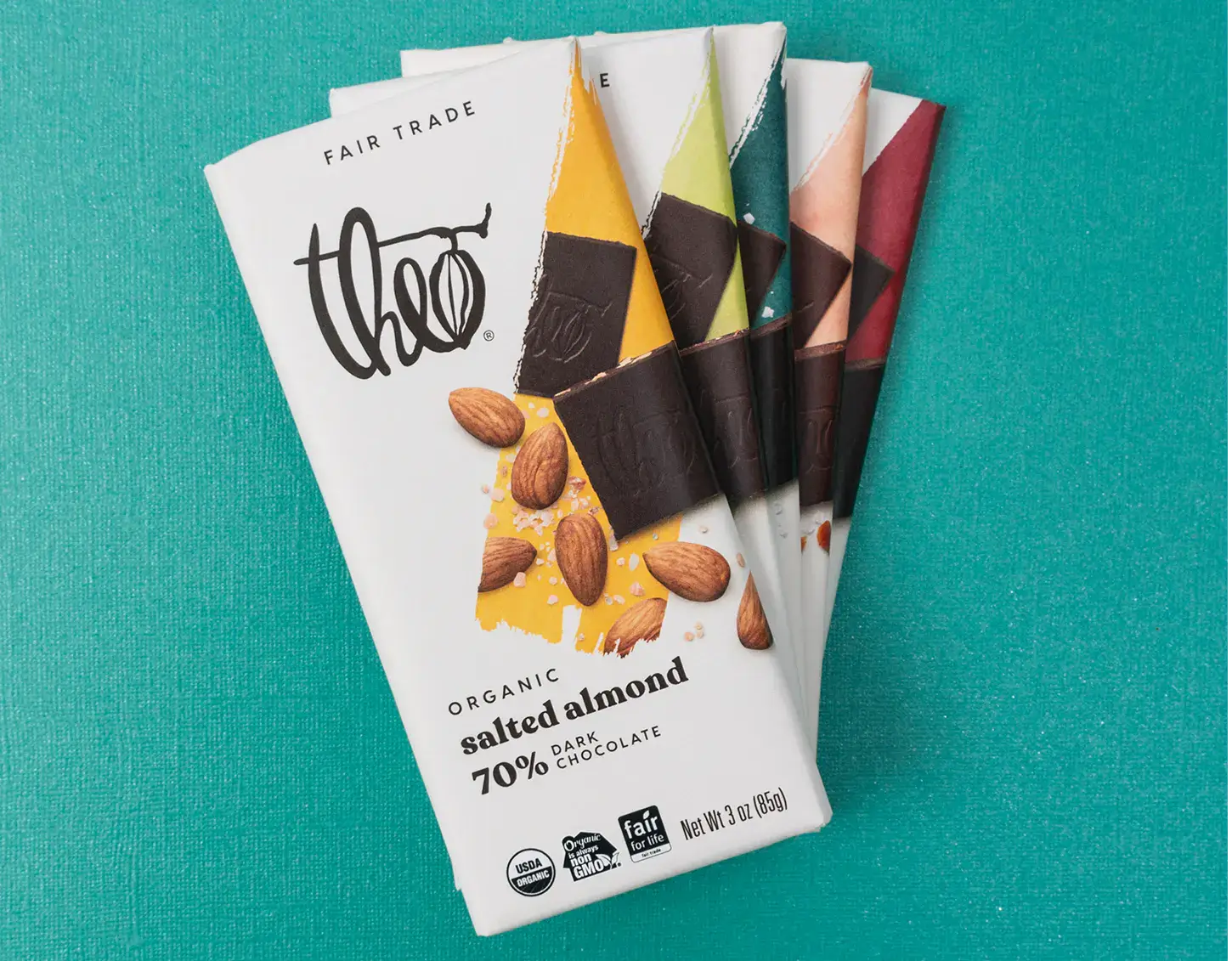 Theo chocolate bars with different flavors on a teal background