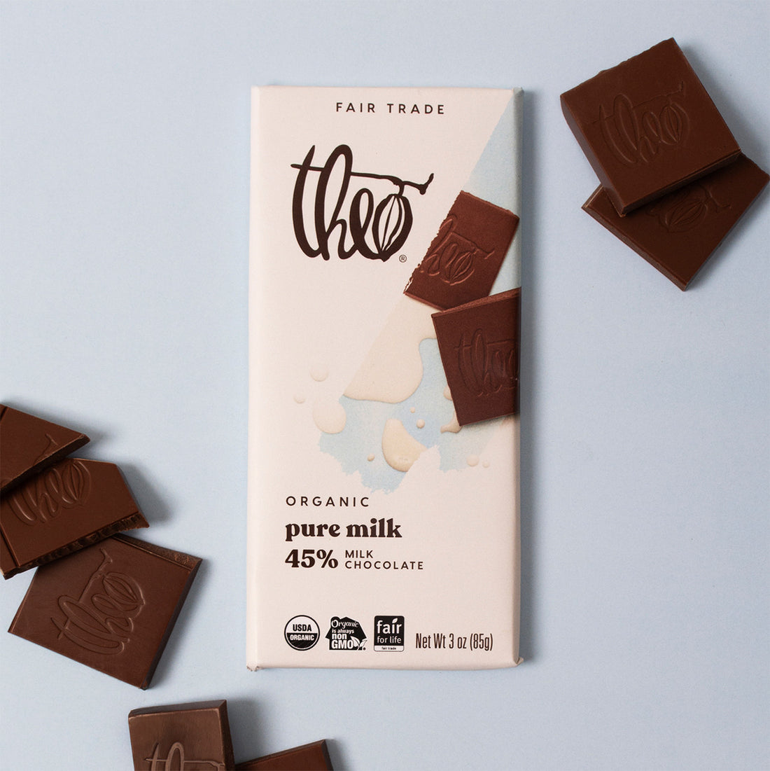 Theo organic pure milk chocolate bar with packaging on a light gray background