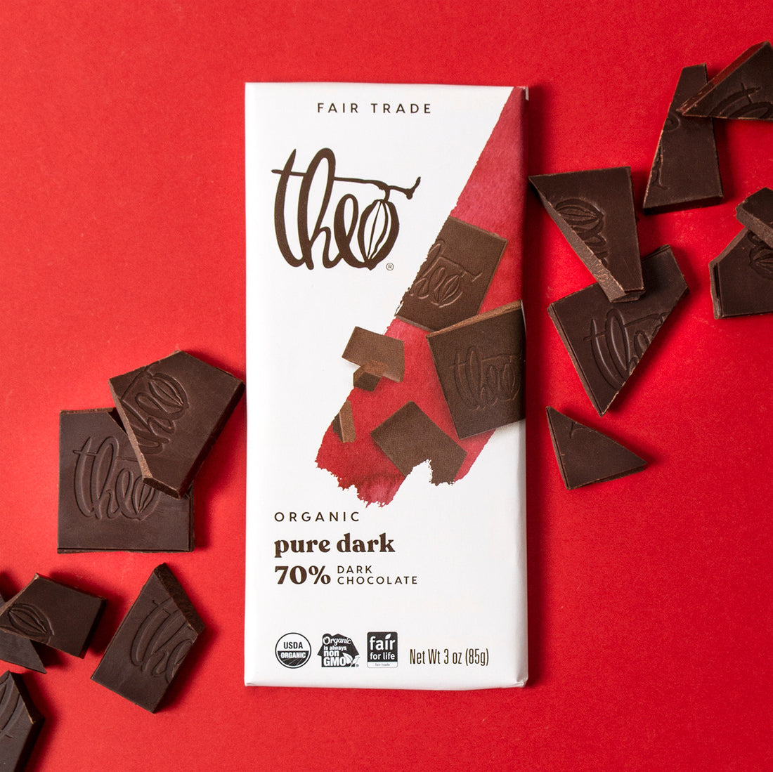 Theo Organic pure dark 70% dark chocolate bar with pieces of chocolate on a red background
