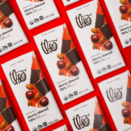 Multiple Theo Organic Cherry Almond 70% Dark Chocolate bars on a red background