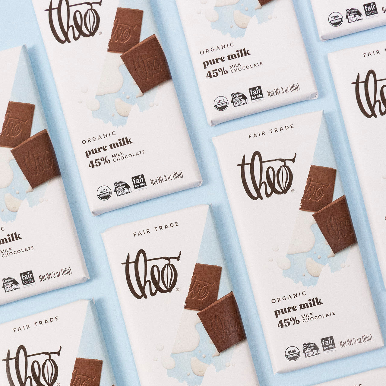 Multiple Theo milk chocolate bars and packaging on a light blue background