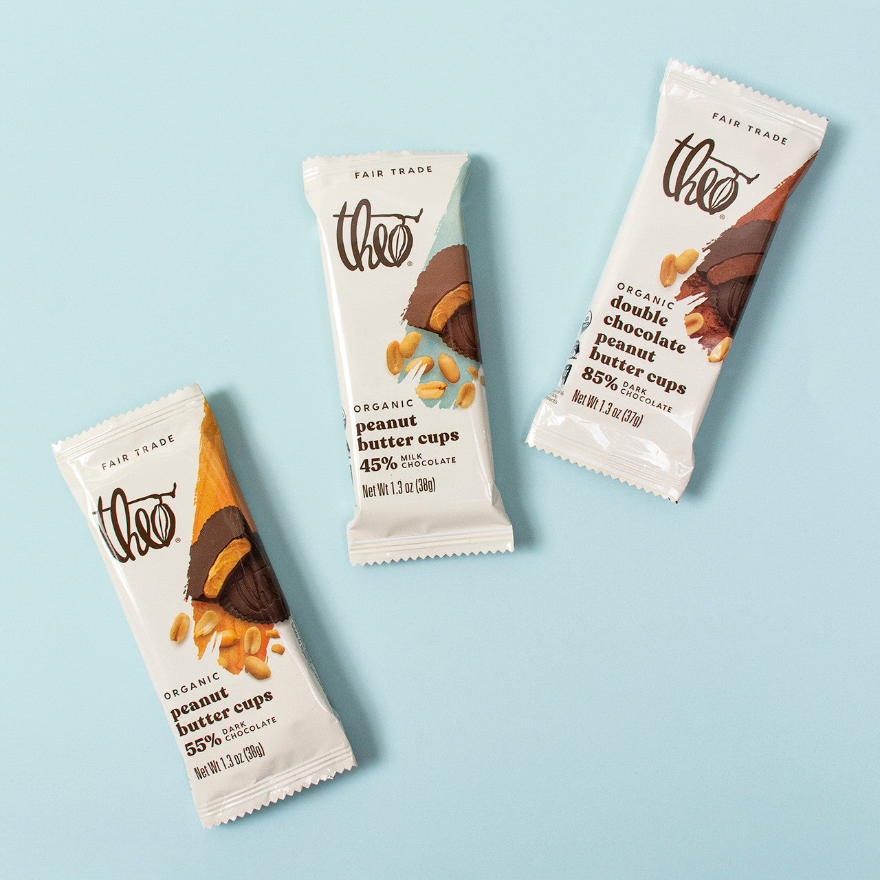 Three Theo peanut butter cups with different flavors on a light blue background