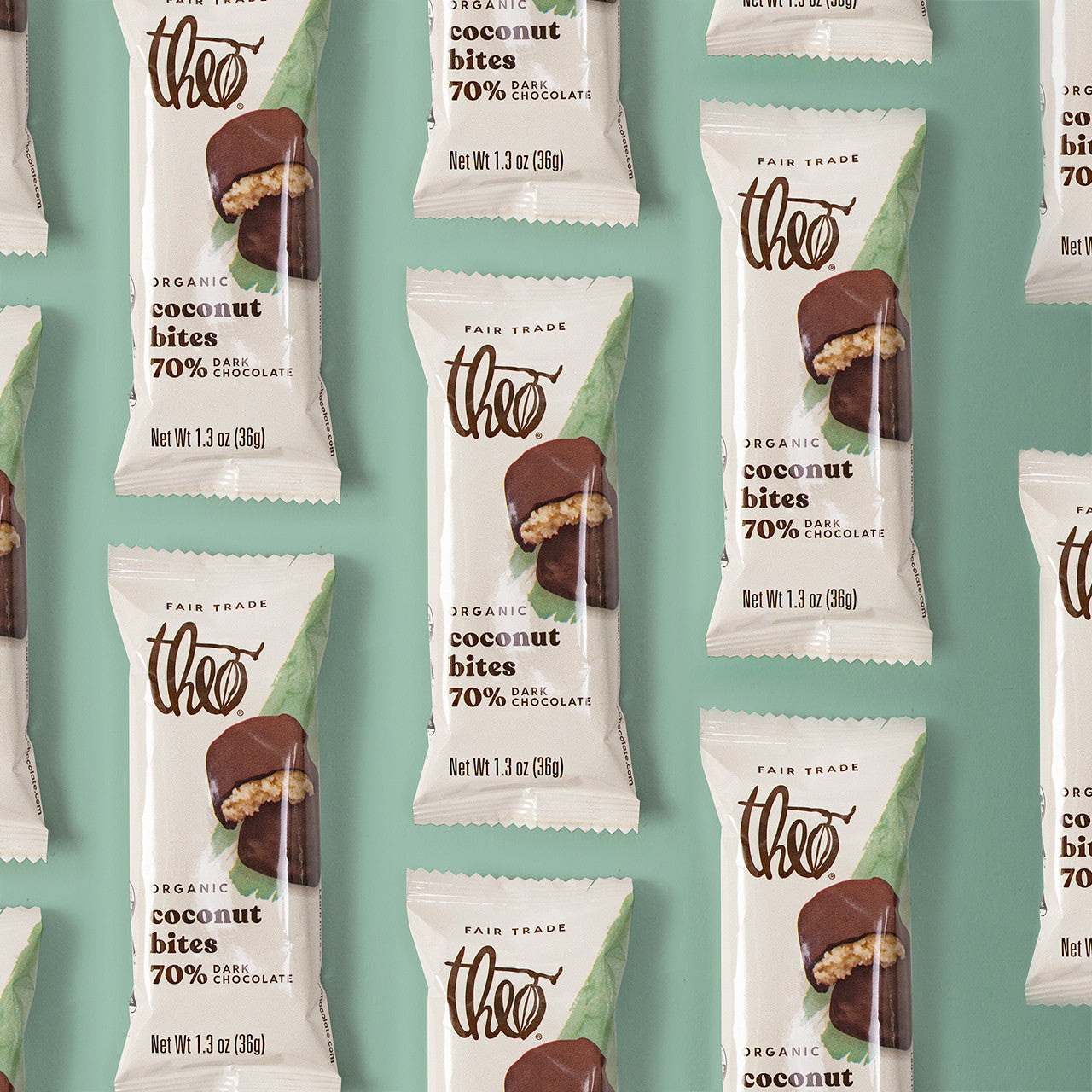 Multiple packages of Theo Organic Coconut Bites 70% Dark Chocolate on a teal background