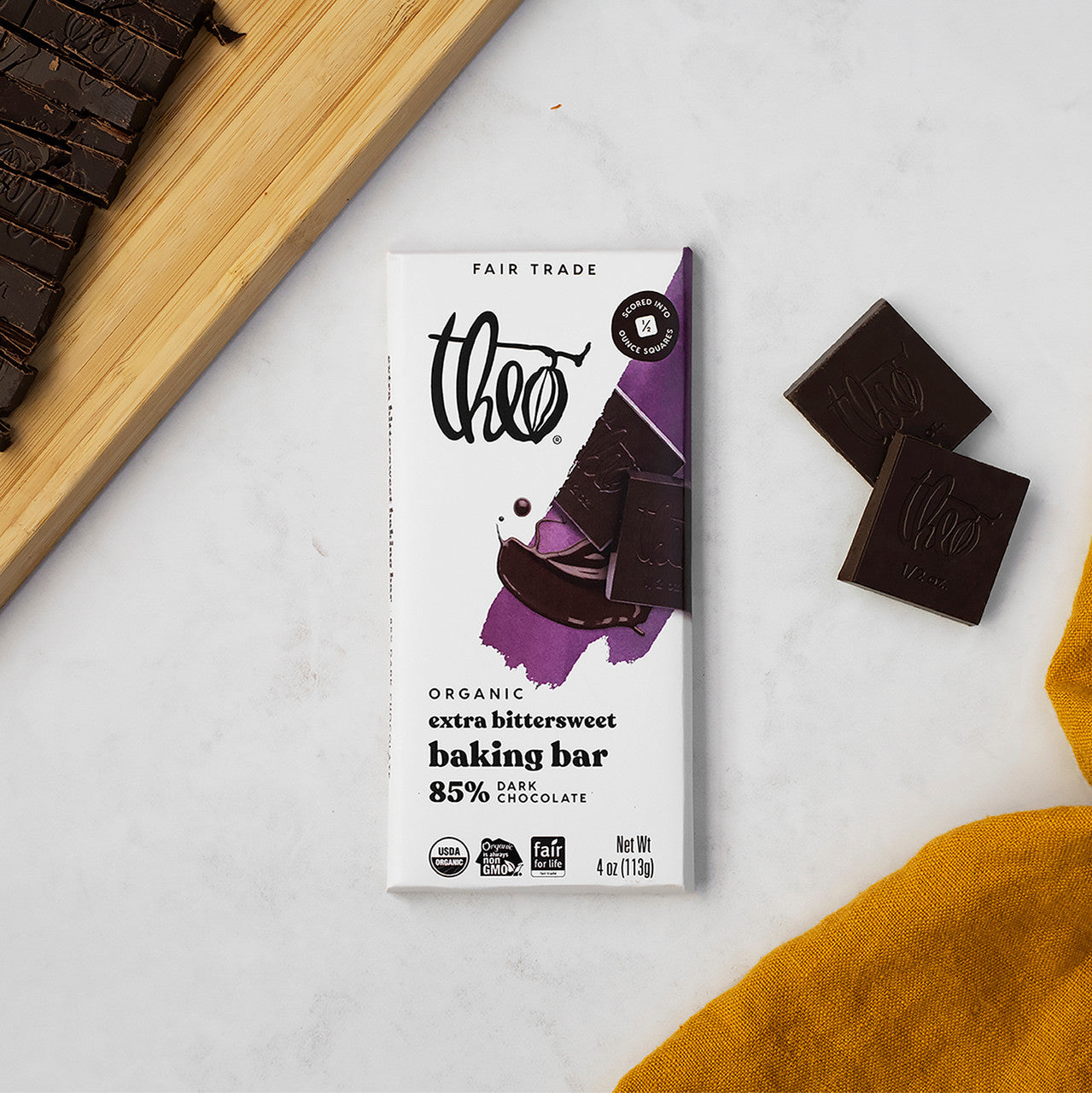 Theo organic extra bitterweet baking bar on a white surface with chocolate pieces.