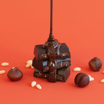 Stack of chocolate bars with a drizzle of chocolate on an orange background