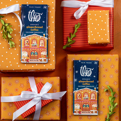 Theo Organic Gingerbread Toffee dark chocolate bars on orange gift boxes with white ribbons.