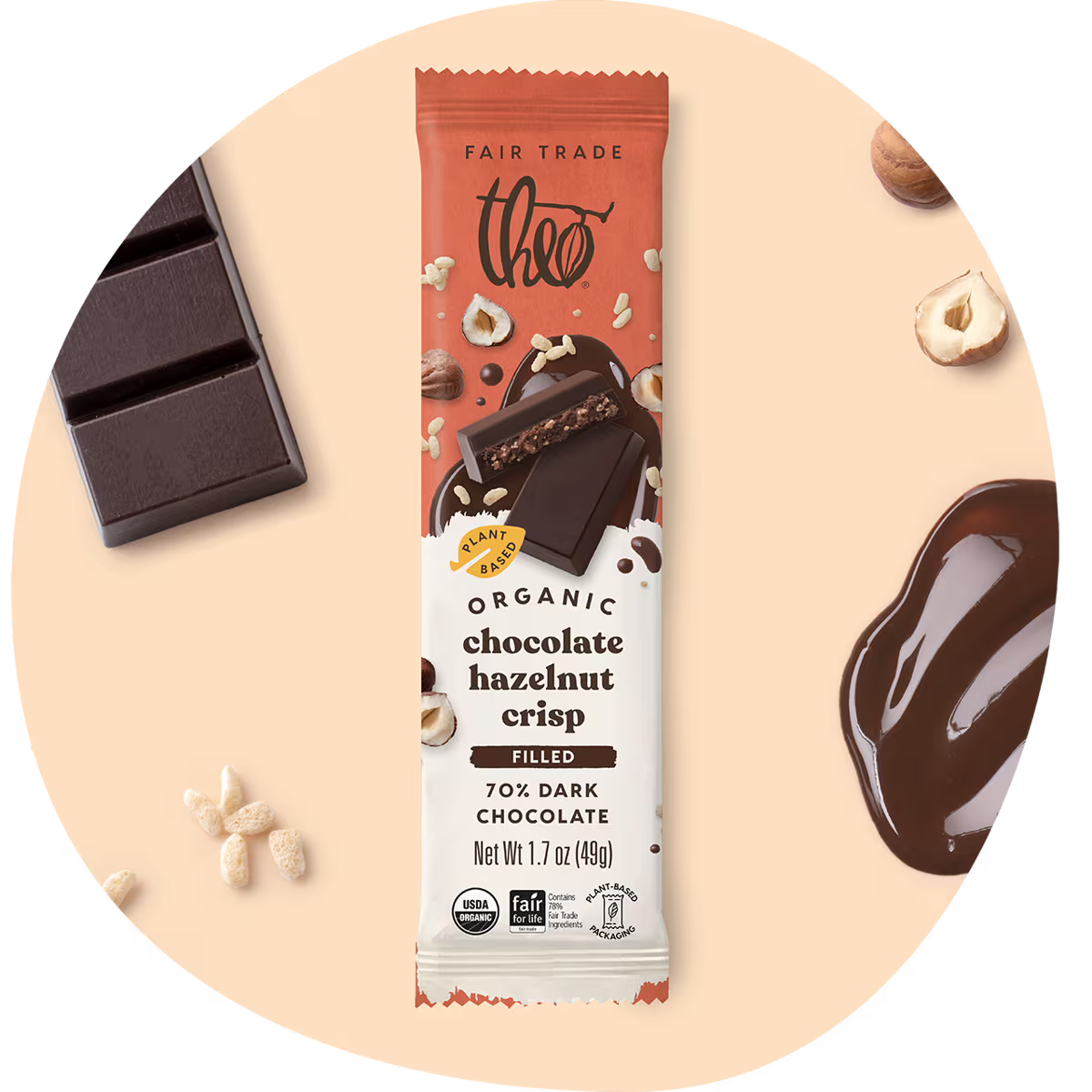 Theo Organic Chocolate Hazelnut Crisp bar packaging on a beige background with chocolate and nuts.
